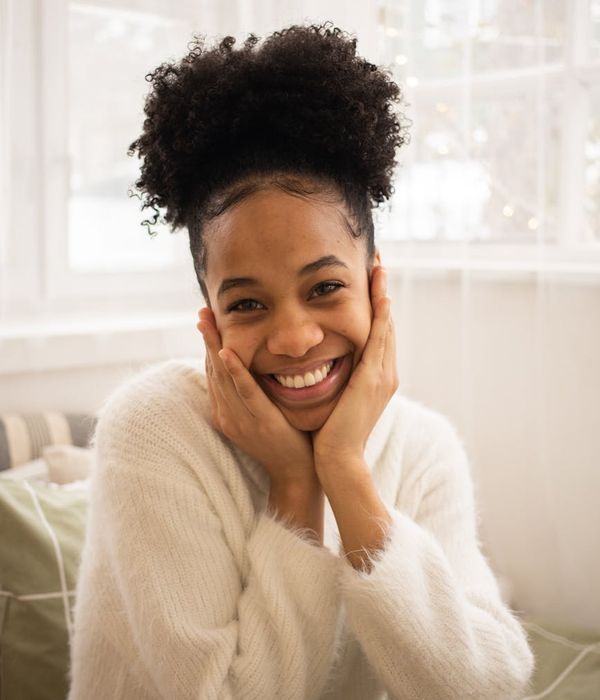 Woman feeling energetic and serene in a bright, calm room.